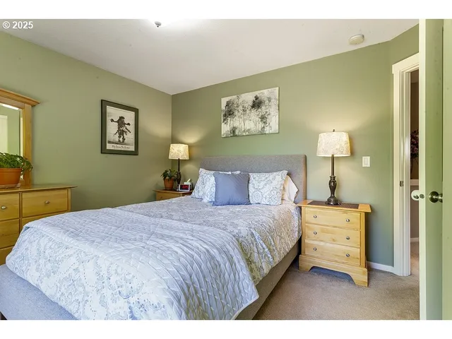 a bedroom with a bed and a painting on the wall