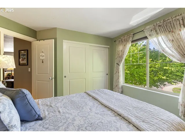 a bedroom with a bed and a large window