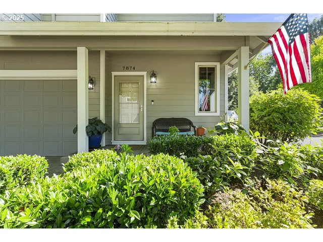 a front view of a house with a flower garden