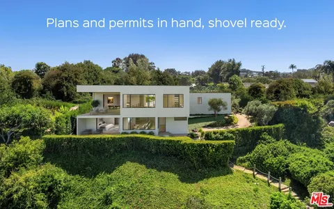 a view of a house with a yard and potted plants