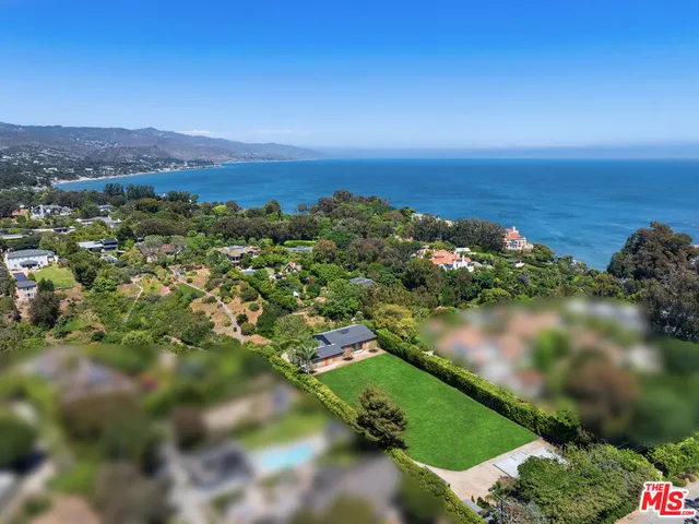 an aerial view of residential houses with outdoor space and lake view