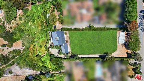 an aerial view of residential houses with outdoor space and lake view