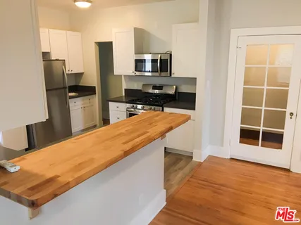 a kitchen with stainless steel appliances a refrigerator and a stove top oven