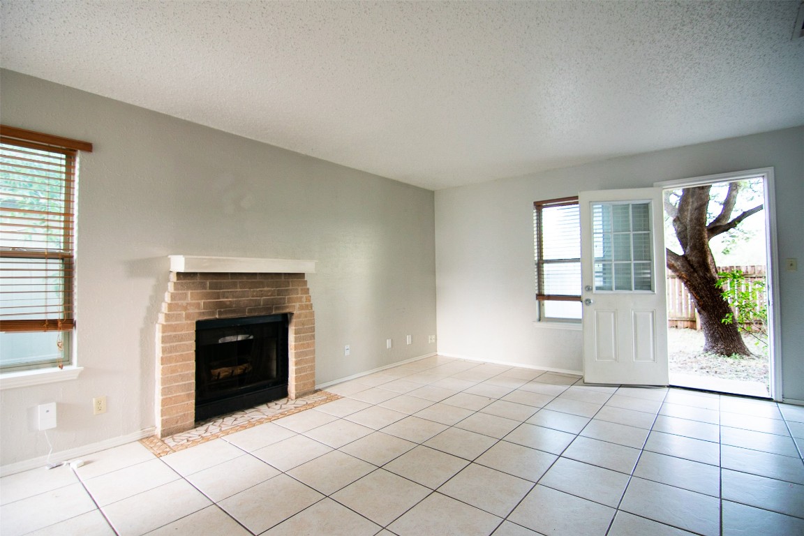 8807 Springmail Circle, Unit A Austin, TX 78729 - Photo 14 of 27 a view of empty room with windows and fireplace