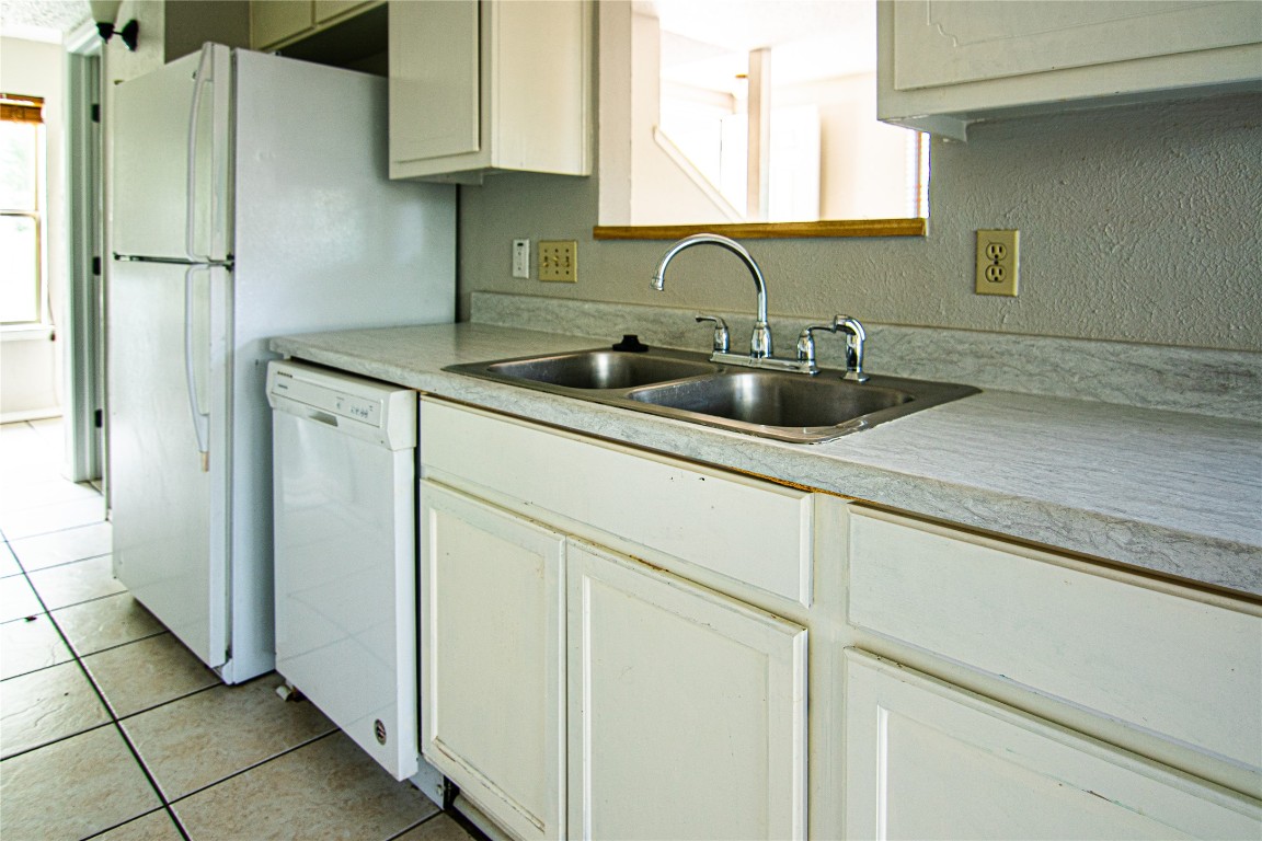 8807 Springmail Circle, Unit A Austin, TX 78729 - Photo 17 of 27 a kitchen with stainless steel appliances granite countertop a sink refrigerator and cabinets