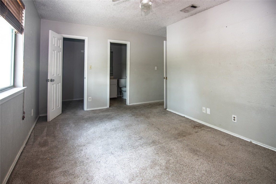 8807 Springmail Circle, Unit A Austin, TX 78729 - Photo 19 of 27 an empty room with windows and closet