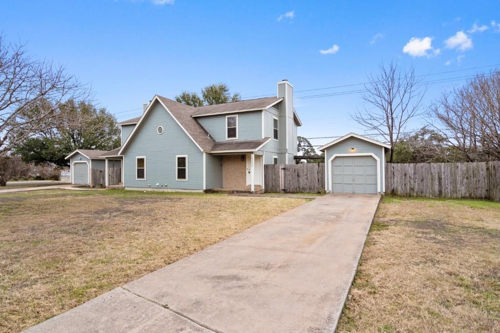8807 Springmail Circle, Unit A Austin, TX 78729 - Photo 2 of 27 a front view of a house with a yard and wooden fence