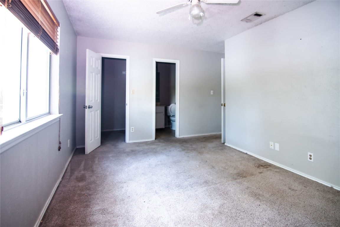 8807 Springmail Circle, Unit A Austin, TX 78729 - Photo 21 of 27 an empty room with windows and closet