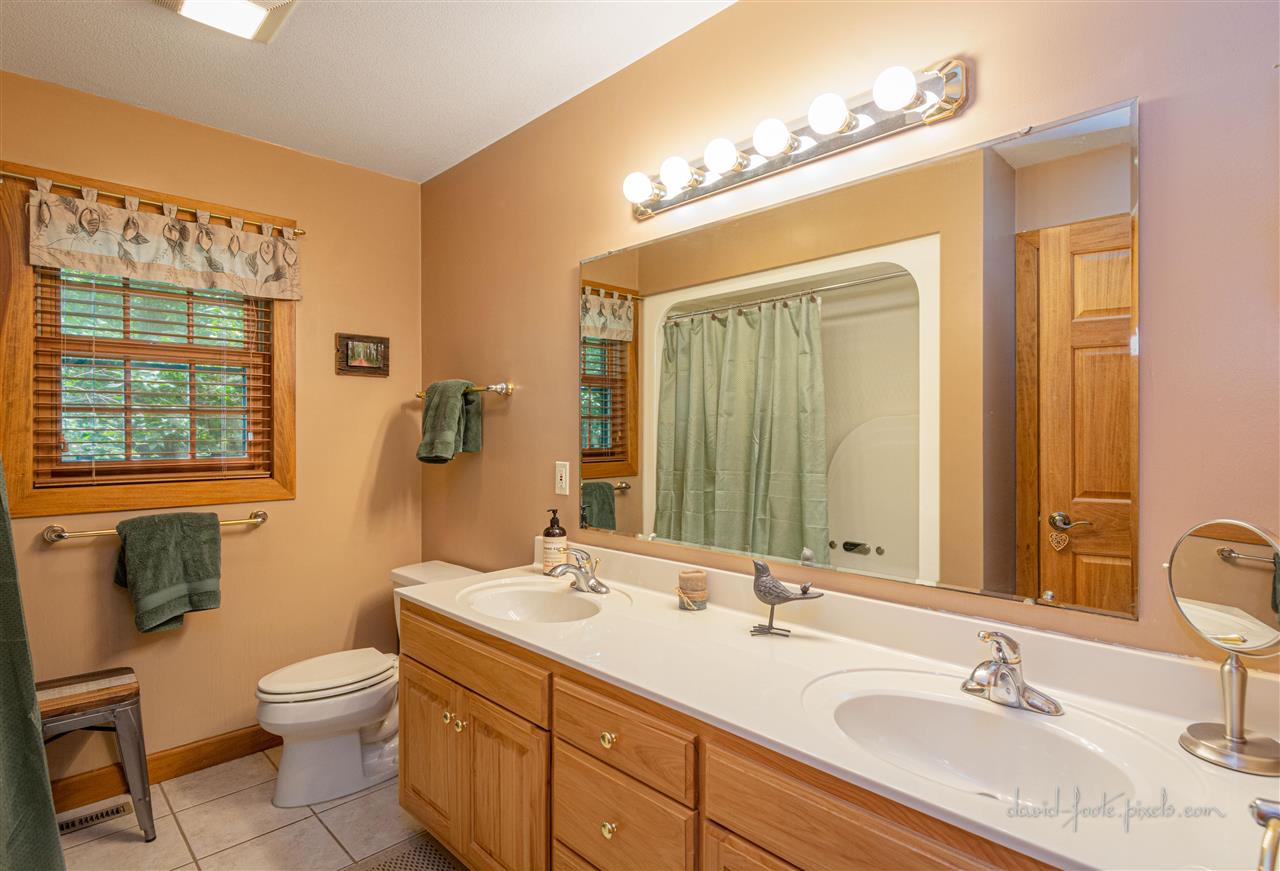 8620 Fisher Road Hanover, IL 61041 - Photo 26 of 49 a bathroom with a granite countertop toilet a sink a mirror a window and vanity