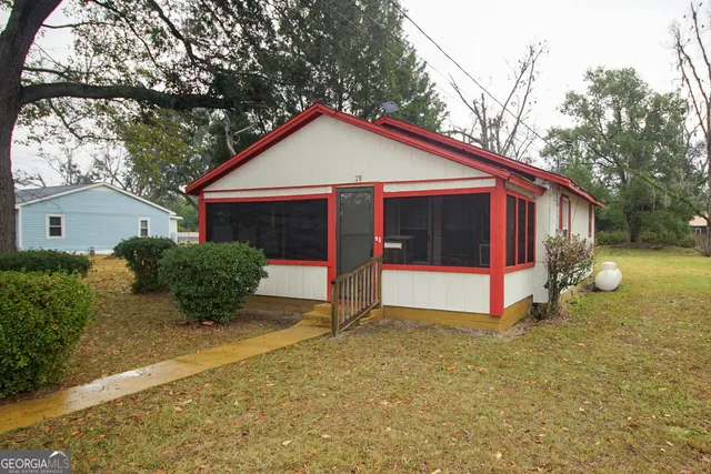 a view of a house with a yard and large tree