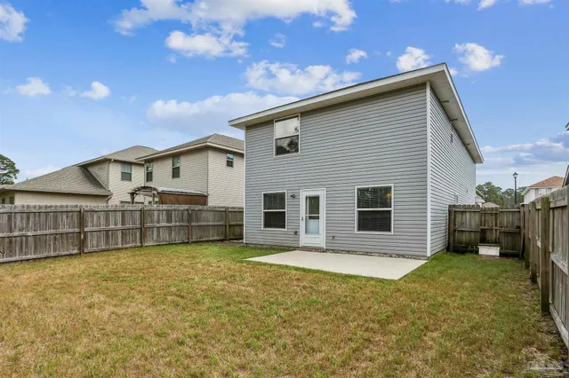 a view of a house with a patio and a yard