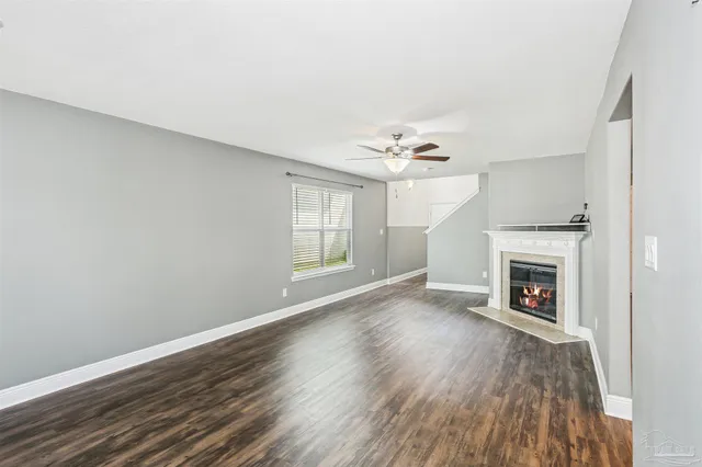 wooden floor fireplace and windows in an empty room