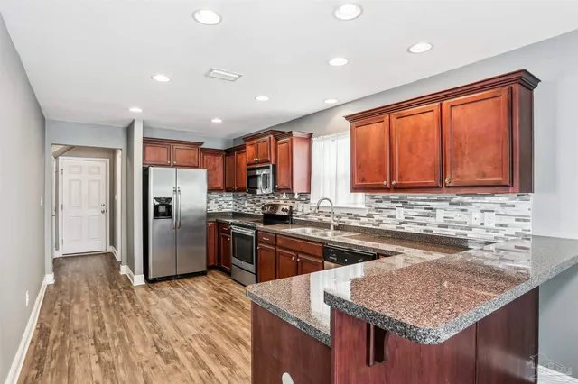 a kitchen with stainless steel appliances granite countertop a sink stove and refrigerator