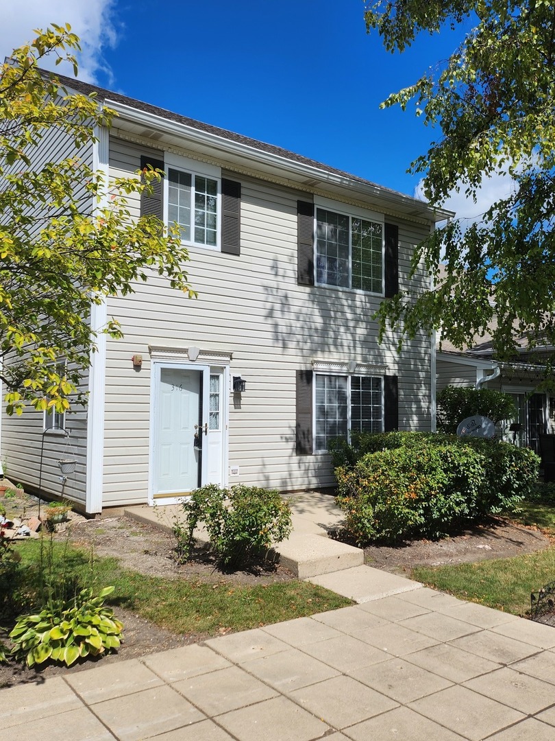 316 East Victoria Circle, Unit 316 North Aurora, IL 60542 - Photo 1 of 54 a front view of a house with garden