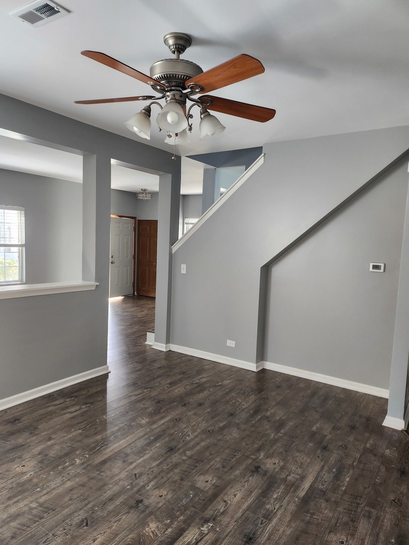 316 East Victoria Circle, Unit 316 North Aurora, IL 60542 - Photo 11 of 54 a view of an empty room with a window and wooden floor