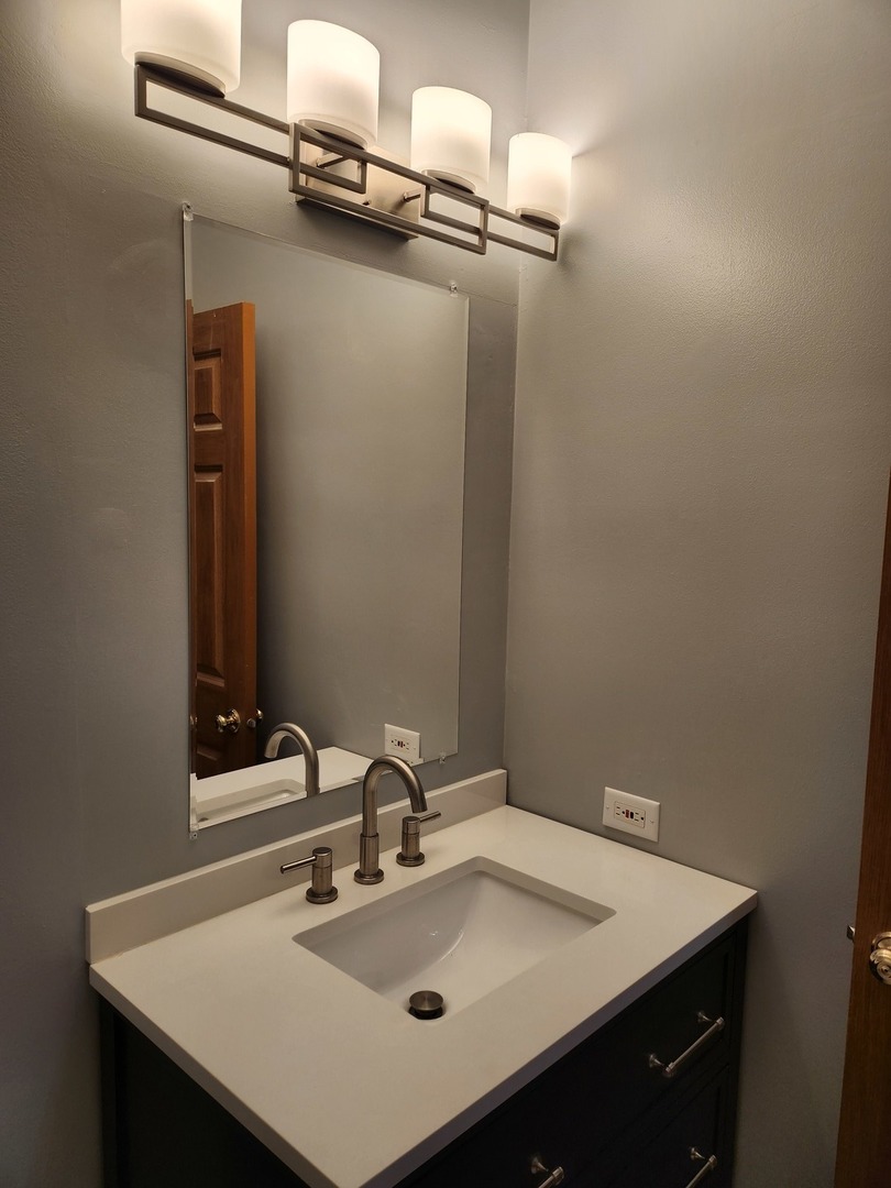 316 East Victoria Circle, Unit 316 North Aurora, IL 60542 - Photo 18 of 54 a bathroom with a sink and a mirror