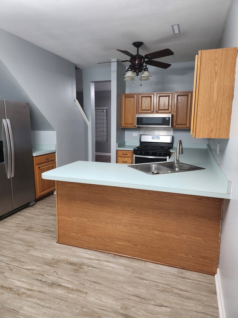316 East Victoria Circle, Unit 316 North Aurora, IL 60542 - Photo 21 of 54 a kitchen view with wooden floor and a refrigerator