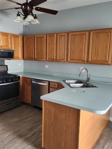 a view of a kitchen with kitchen island a stove and a sink