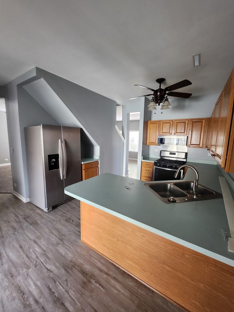 316 East Victoria Circle, Unit 316 North Aurora, IL 60542 - Photo 24 of 54 a view of a livingroom with furniture and a ceiling fan