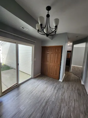 a view of an empty room and wooden floor and a window