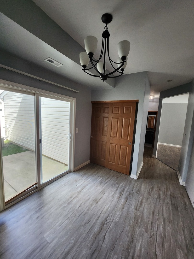 316 East Victoria Circle, Unit 316 North Aurora, IL 60542 - Photo 28 of 54 a view of a livingroom with wooden floor and chandelier