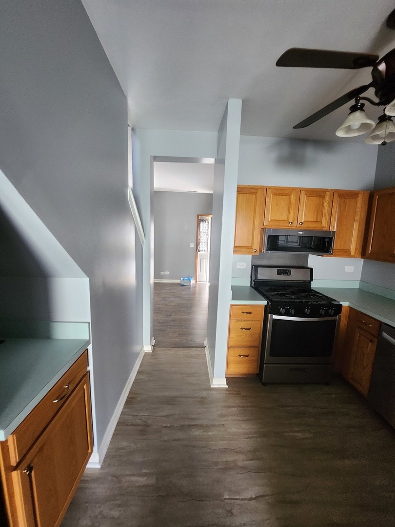 316 East Victoria Circle, Unit 316 North Aurora, IL 60542 - Photo 29 of 54 a kitchen with stainless steel appliances kitchen island granite countertop a refrigerator and a stove