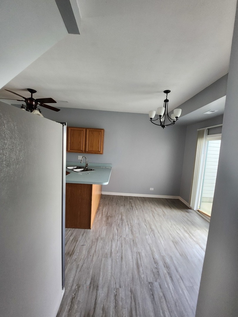 316 East Victoria Circle, Unit 316 North Aurora, IL 60542 - Photo 30 of 54 wooden floor in an empty room and a window