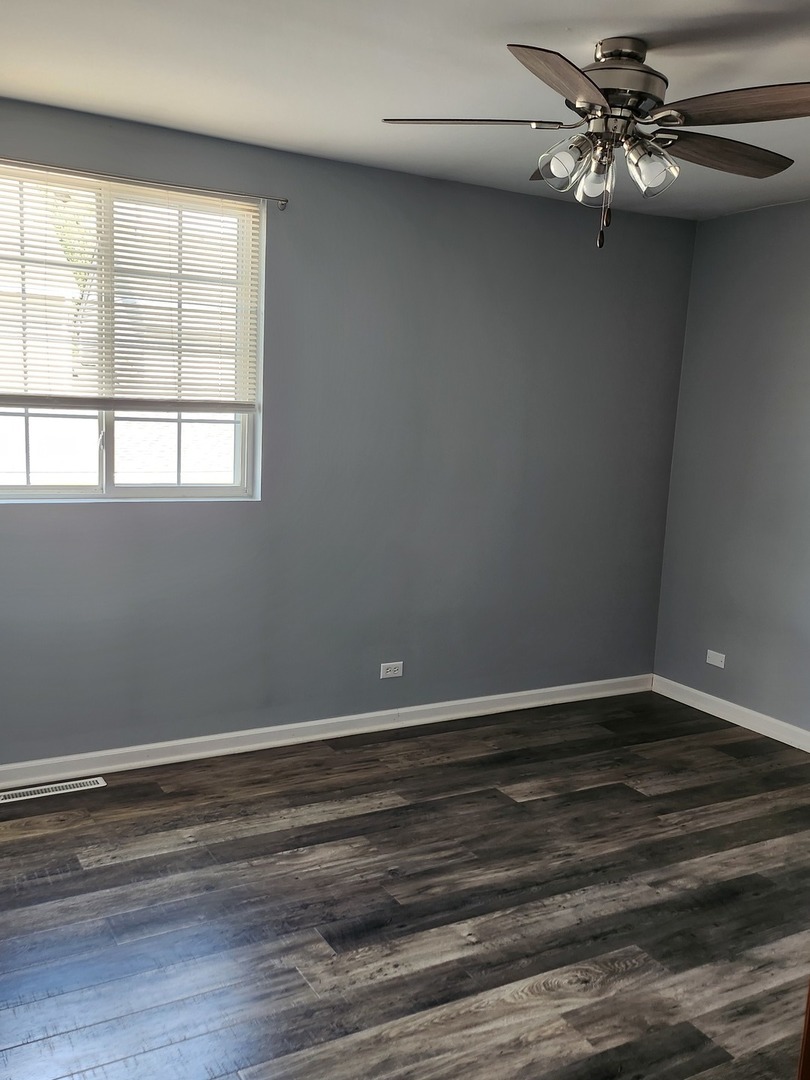 316 East Victoria Circle, Unit 316 North Aurora, IL 60542 - Photo 40 of 54 wooden floor in an empty room with a window