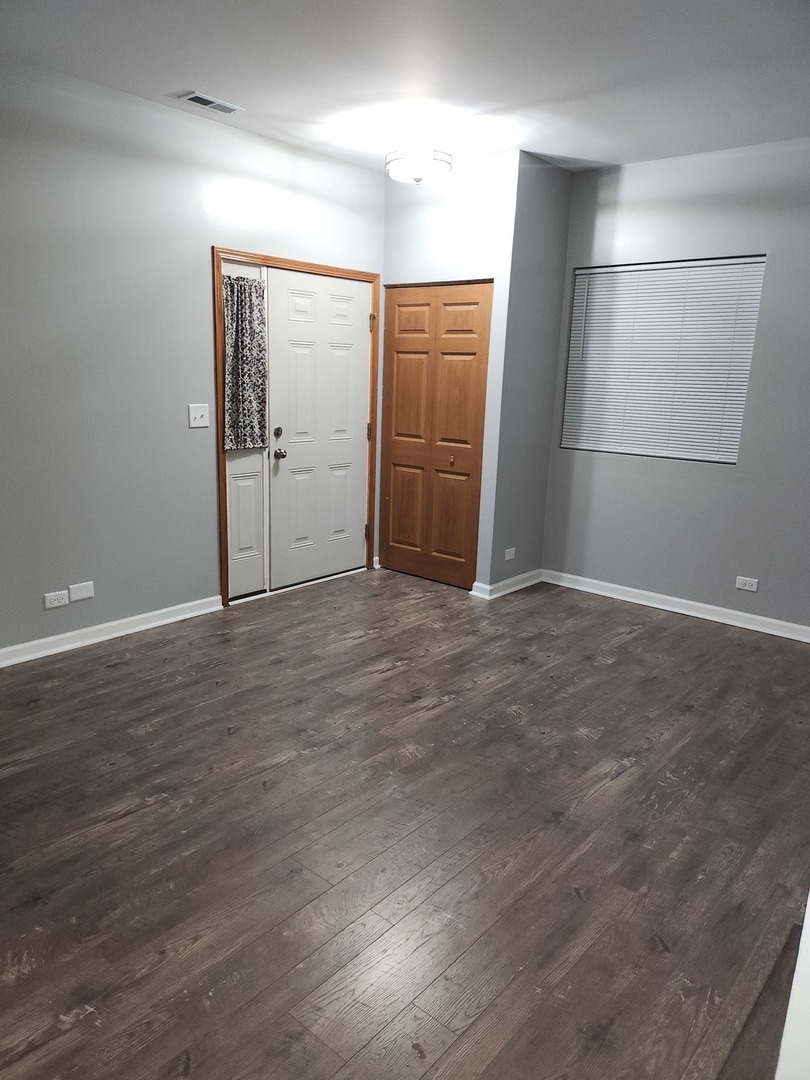 316 East Victoria Circle, Unit 316 North Aurora, IL 60542 - Photo 4 of 54 an empty room with wooden floor and windows