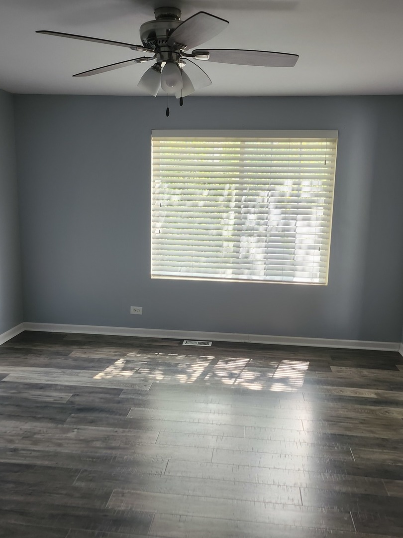316 East Victoria Circle, Unit 316 North Aurora, IL 60542 - Photo 46 of 54 a view of an empty room with window and wooden floor