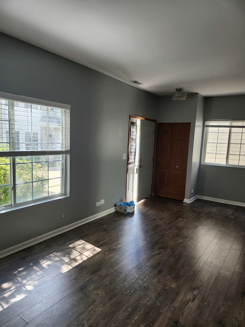 316 East Victoria Circle, Unit 316 North Aurora, IL 60542 - Photo 5 of 54 an empty room with wooden floor and windows