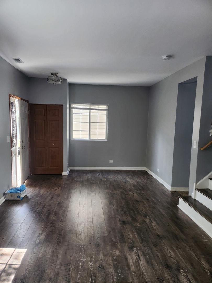 316 East Victoria Circle, Unit 316 North Aurora, IL 60542 - Photo 6 of 54 an empty room with wooden floor and windows