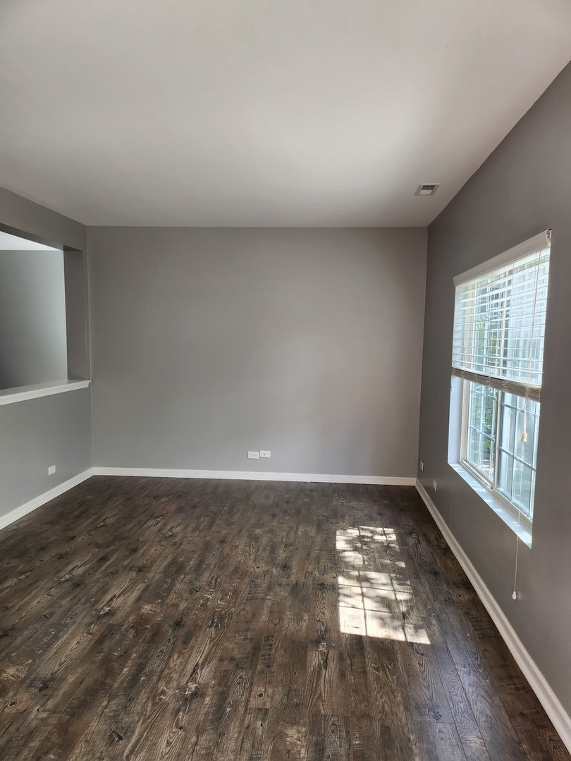 316 East Victoria Circle, Unit 316 North Aurora, IL 60542 - Photo 7 of 54 wooden floor in an empty room with a window