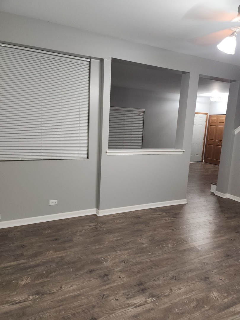 316 East Victoria Circle, Unit 316 North Aurora, IL 60542 - Photo 10 of 54 a view of an empty room with wooden floor and a window