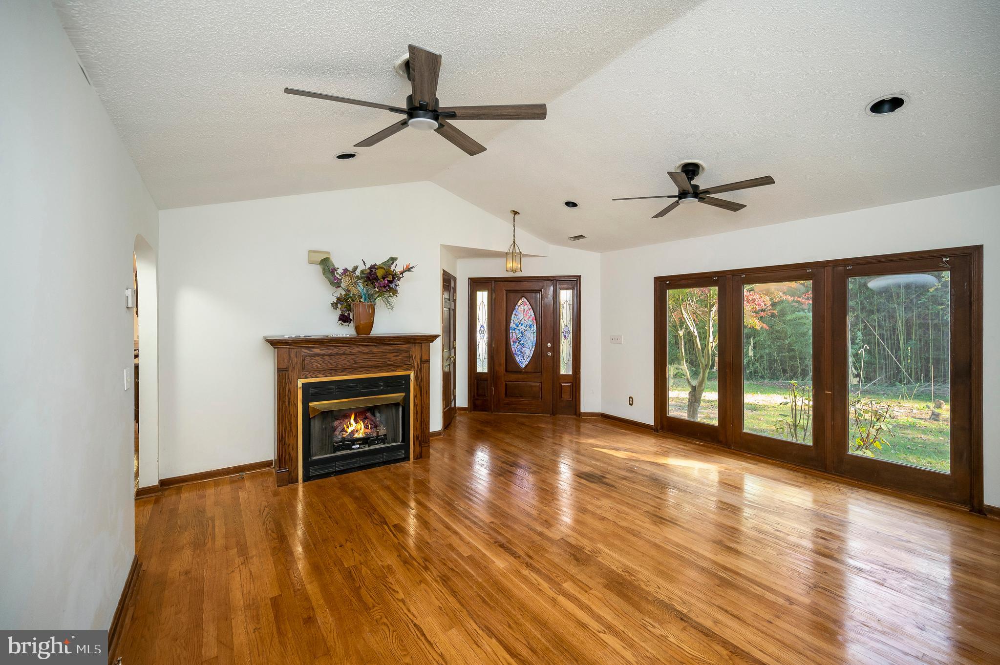 6709 Marye Road Spotsylvania, VA 22551 - Photo 18 of 73 a view of empty room with wooden floor fireplace and windows