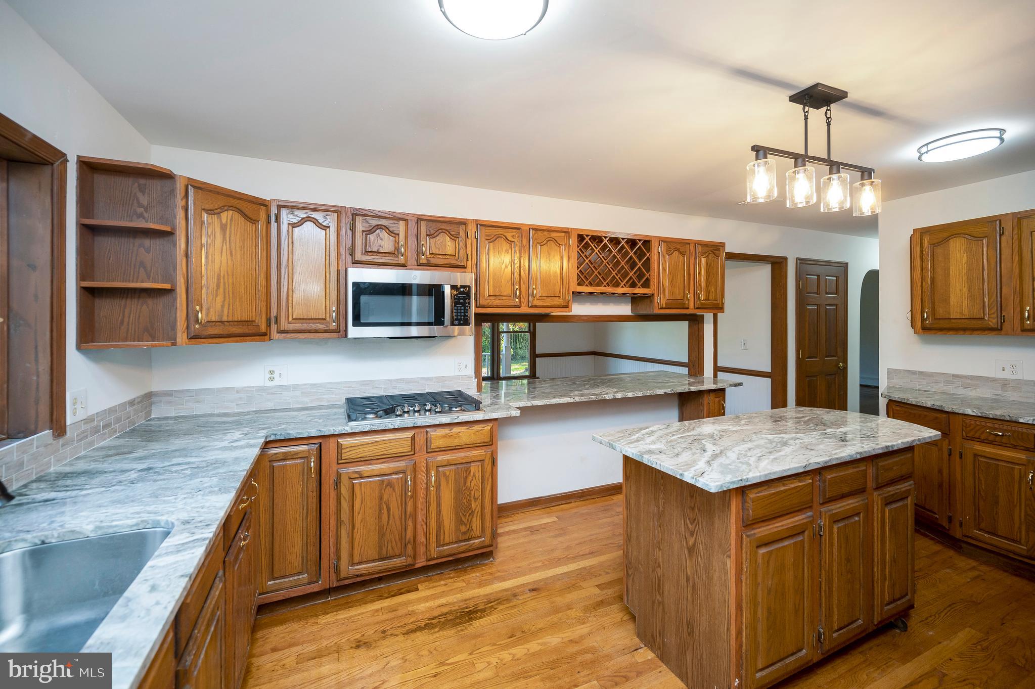 6709 Marye Road Spotsylvania, VA 22551 - Photo 41 of 73 a kitchen with stainless steel appliances granite countertop wooden cabinets a oven and dishwasher with wooden floor