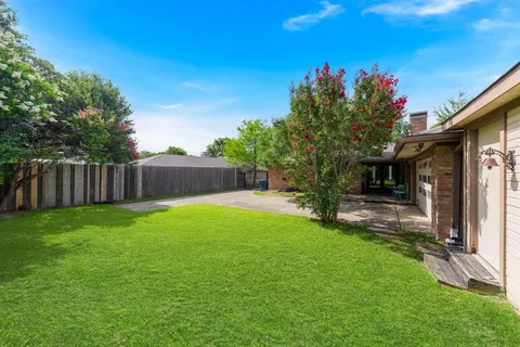 a backyard of a house with table and chairs