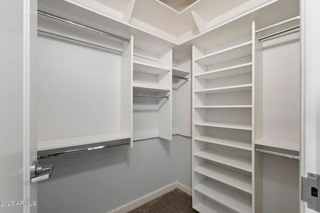 a view of walk in closet with clothes and shoes