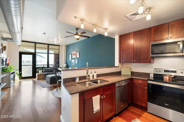 a kitchen with stainless steel appliances granite countertop a sink stove and refrigerator