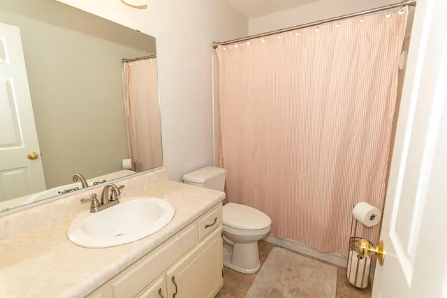 a bedroom with a bed and a large mirror on the dresser