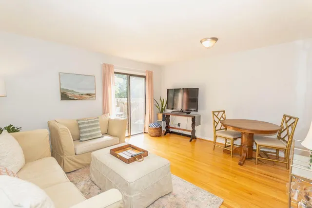 a living room with furniture a flat screen tv and a large window