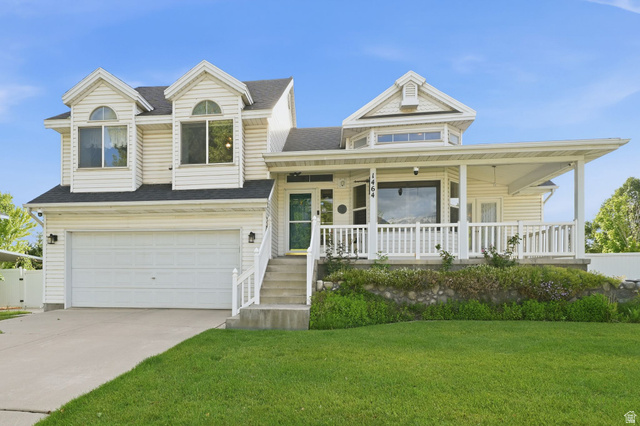 1464 990 West Provo, UT 84601 - Photo 1 of 41 Two-story residence featuring light-colored siding, a covered front porch with white railings, and a two-car garage