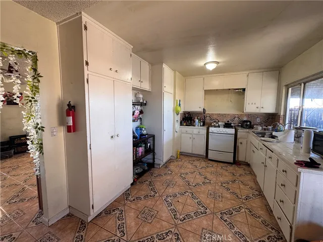a kitchen with white cabinets and refrigerator