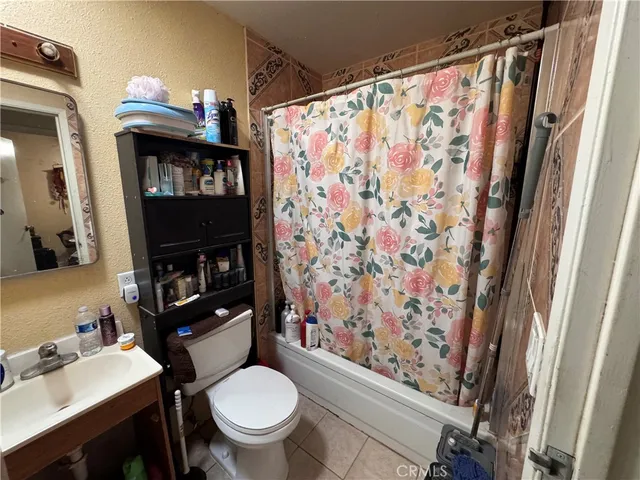 a bathroom with a sink a toilet and shower curtain