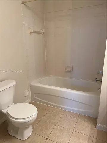 a bathroom with a toilet and a bath tub
