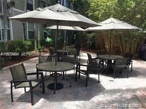 a patio with tables and chairs and a umbrella