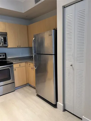 a kitchen with a refrigerator sink and cabinets