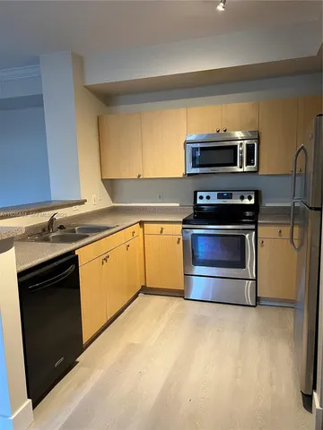 a kitchen with stainless steel appliances a stove a microwave and a sink