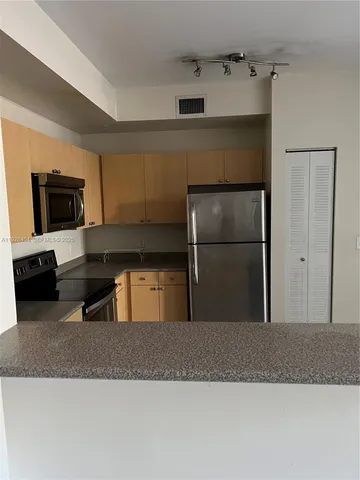 a kitchen with a refrigerator and a sink
