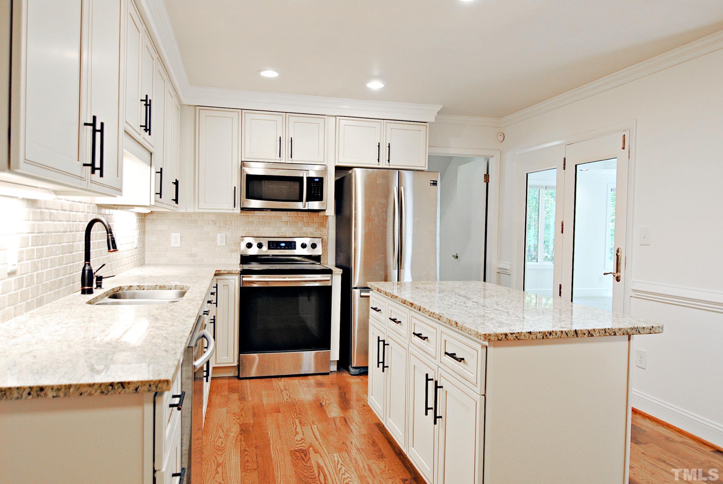 7106 Matthews Road Durham, NC 27712 - Photo 11 of 30 a kitchen with stainless steel appliances granite countertop a refrigerator and a stove